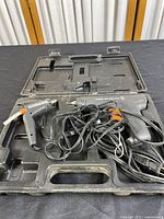 Two PEMCO hot glue guns on black molded carrying case, one larger 40W and one smaller 10W model, cords entangled