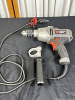 View of the full drill, power cord, and auxiliary handle