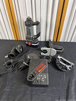 Full lot showing ROTOZIP rotary tool, charger, multiple attachments placed on black surface.