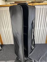 Black wheeled travel bag standing open showing the interior compartments and durable fabric construction.