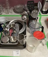 Overview photo of the baking lot items arranged on a counter including muffin tins, cake pan, measuring cups, bowls, plates, kitchen utensils, and trays.