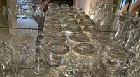 Photo showing multiple rows of clear glasses upside down, including wide-bowl glasses likely used for cognac and other beverages.
