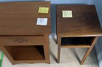 Two wooden nightstands side by side, one lighter in color with a drawer and open shelf, the other darker wood with an open shelf only.