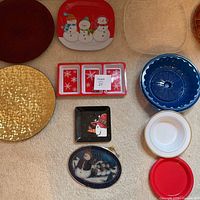 Overview of seven platters including gold textured, Christmas snowmen designs, blue tray, and smaller round plates.