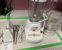 Hailton Beach blender with clear plastic pitcher and control panel with preset buttons, placed on countertop.