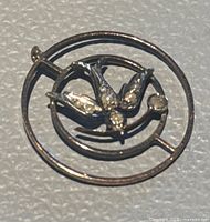 Front view of the 9 carat rose gold antique pendant showing bird motif and two small embedded gemstones within circular and oval framing.