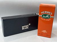 Both original boxes side by side, Mont Blanc in black, Hermes in orange.