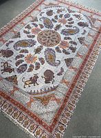 Full view of Persian tablecloth laid flat, showing central medallion and detailed motifs including animals, flowers, and paisley with ornate borders.