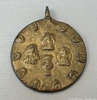 Front side of the bronze pendant showing three embossed Buddha figures with a vase in the center and surrounding design elements.