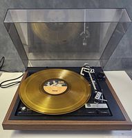 Top-down view with dust cover open showing platter, tonearm, controls and mounted cartridge