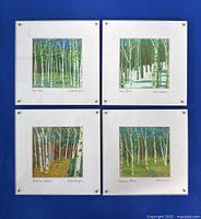 Four fiber art prints by Lisa and Lori Lubbesmeyer, arranged on blue background showing all four pieces titled and signed.