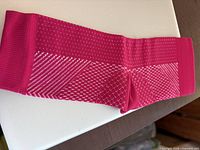 Single red ankle compression sock laid flat showing knit pattern and compression zones.