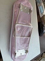 Underside of the arm rest showing metal foldable support frame attached to padded surface.