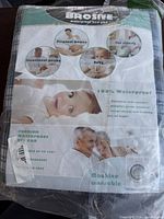 Photo of the original packaging of the Brosive waterproof bed pad, showing product use cases and features.
