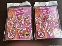 Two unopened adult party games titled 'Junk on the Hunk' in sealed plastic packaging showing cartoon penis illustrations on pink backgrounds.