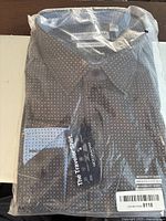 Front of packaged men's shirt showing patterned fabric, Nick Graham brand tag and modern fit label.