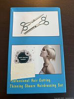 Box for professional hair cutting and thinning shears set, showing image of two scissors: one regular cutting shear and one thinning shear, with text indicating over 10,000 sales. Box states 'Professional Hair Cutting Thinning Shears Hairdressing Set'.