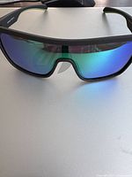 Front view of sunglasses showing blue mirrored lenses and black frame on white surface.