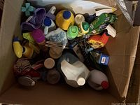 Top view of box showing various cleaning bottles, cloths, and tools packed inside.