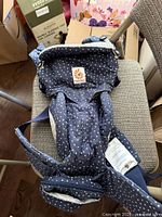 Top view of Ergobaby 360 baby carrier showing star pattern, front pouch, and label.