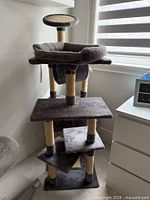 Full view from front showing five levels, circular top perch, and sturdy base with rope scratch posts.