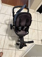 Top view of SmarTrike stroller tricycle showcasing padded seat, harness straps, blue fabric canopy folded back, and handlebars