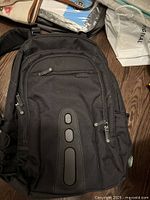Front view of black Targus fabric backpack showing multiple zippered compartments and front detailing