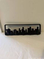 Front view of the Umbra city skyline wall decor showing multiple hooks and overall design.