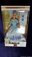 Front view of the boxed Barbie Doll in Peter Rabbit 100 year celebration edition, showing doll in blue and white outfit, petite book, and box design.