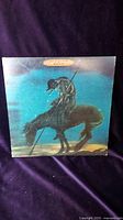 Front cover of The Beach Boys Surf's Up vinyl album showing a lone figure on horseback against a blue background.