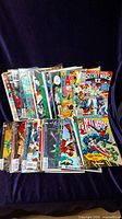 Front view of multiple comic books arranged in two rows showing various titles and colorful covers.