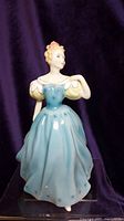 Front view of Royal Doulton Enchantment figurine in blue and yellow dress.