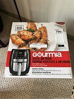 Front of the Gourmia digital air fryer box featuring an image of the air fryer, cooked chicken wings, and product capacity of 5.7L/6QT.