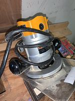 Photo of Black and Decker electric router showing yellow housing and black handles with cord wrapped around