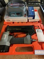 Photo showing the brad nailer, carrying case, and OptiVisor goggles inside the case with some additional boxes.