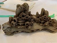 Chinese natural carved stone sculpture depicting a mountain village with detailed mountains and pagoda buildings