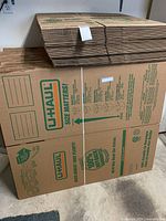 Front view of bundled flat-packed U-Haul boxes showing printed logo and address fields