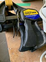 Close-up of Quick-Grip Bapi clamp, black with yellow accents and label visible