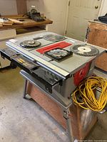 Front and side view of the Craftsman 10-inch table saw with blades on top and attached extension cord.