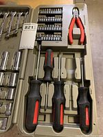 Top portion of tool set showing screwdrivers, pliers, and hex bits in molded slots