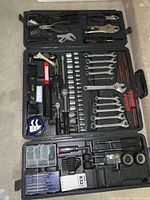 Open black plastic tool case showing organized hand tools including wrenches, sockets, hammer, tape measure, screwdrivers, pliers, and hardware.