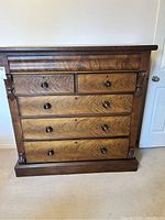 Full front view of the wooden dresser showing drawers and wood grain.