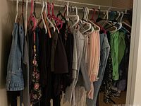 Wide view of all hanging pants including denim, floral, and various colored bottoms