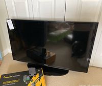 Samsung flat screen LED TV on carpeted floor, untested