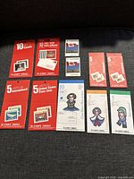 All 11 Canada Post unused postage stamp booklets laid out on a dark surface