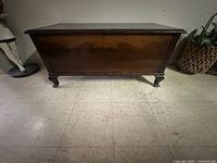 Side view showing shape, legs, and finish of the cedar chest