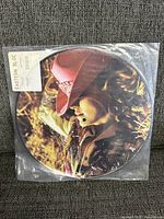Front side of the picture disc vinyl showing Madonna wearing a red cowboy hat and western attire.