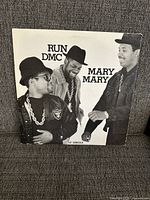 Front cover of the Run DMC Mary Mary 12-inch vinyl single showing three group members dressed in classic hip hop style, black and white photo.