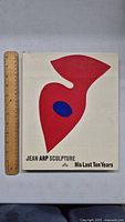 Front cover of vintage 1968 Jean Arp Sculpture art book measuring approx 12 inches with abstract red and blue shape design.