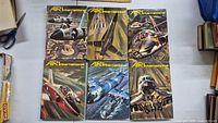 Six hardcover Air International magazines laid out, covers show military aircraft in flight scenes.